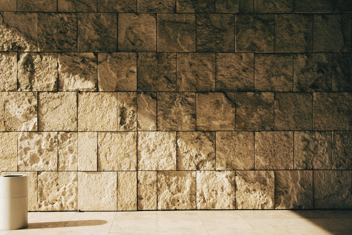 Low sun across a wall of travertine stone blocks